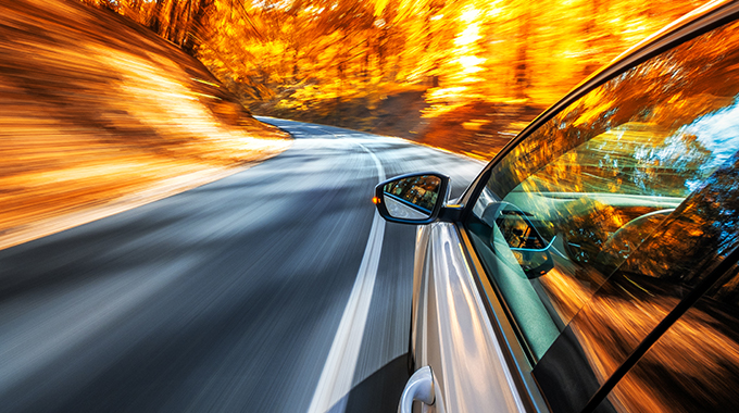Car driving on a road in the fall